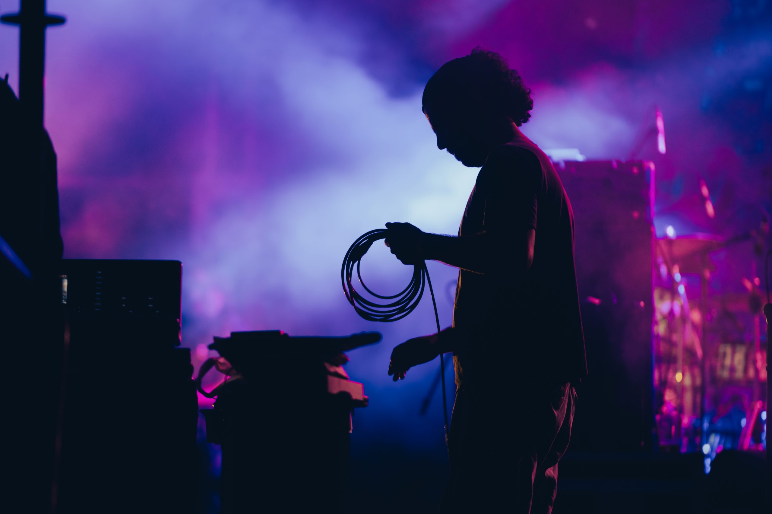 Silhouette of a stage worker standing on a stage with cables location de mobilier lounge